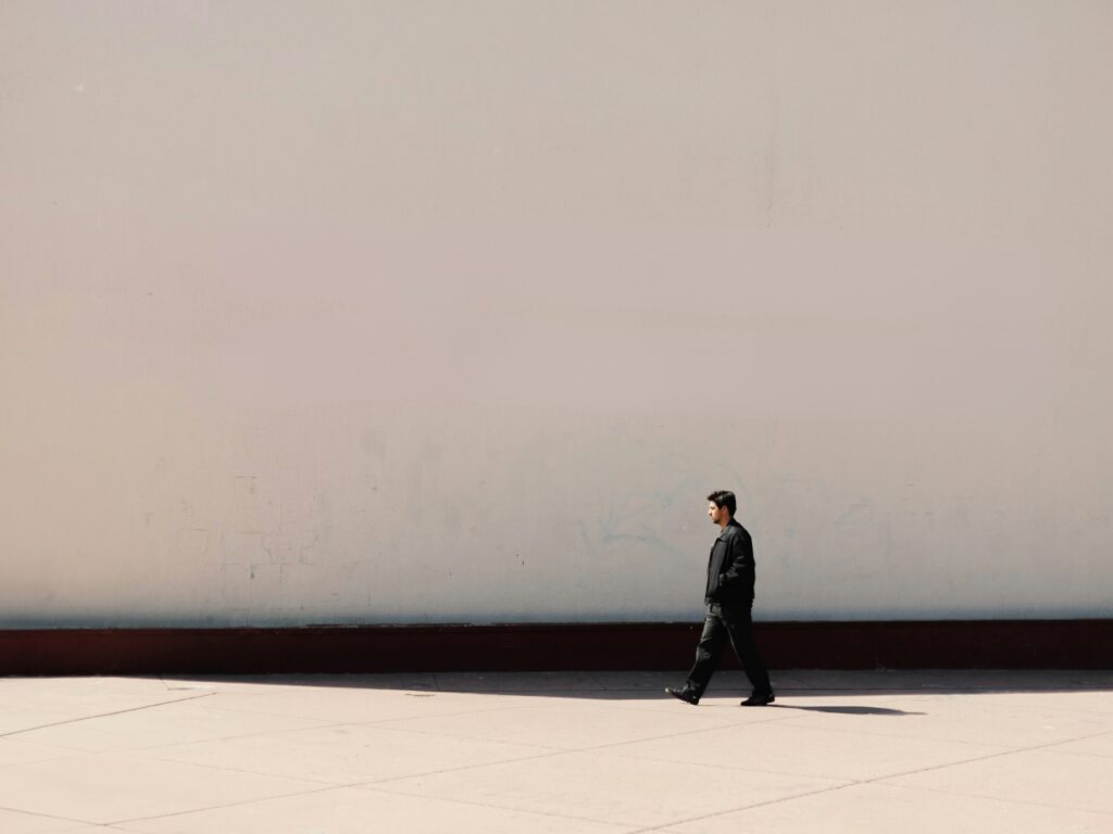 ผนังสีเรียบทั้งผืน มีคนยืนอยู่มุมหนึ่ง